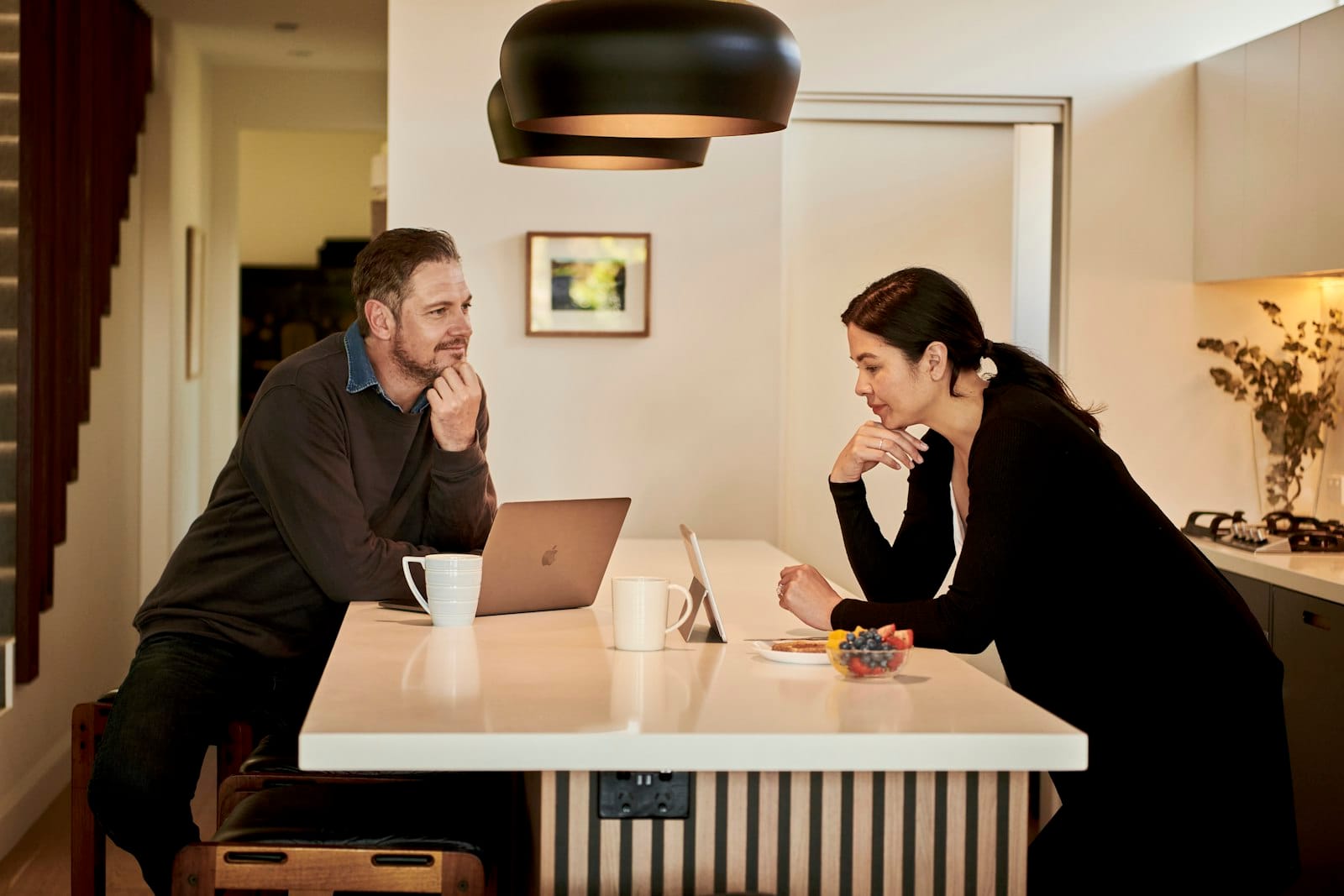 Couple talking at their kitchen bench about how the September 2026 rate rise affects their home loan