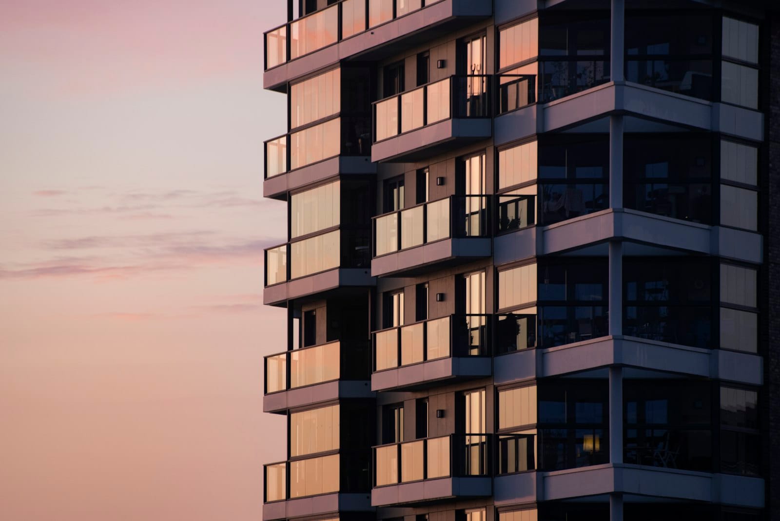 Modern apartment building with balconies against a pink evening sky, the kind of property buyers consider when they borrow for an investment property