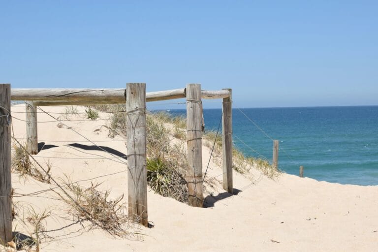 Wooden beach access gate on the sand dunes by the ocean, a coastal scene familiar to anyone using a mortgage broker in the Sutherland Shire