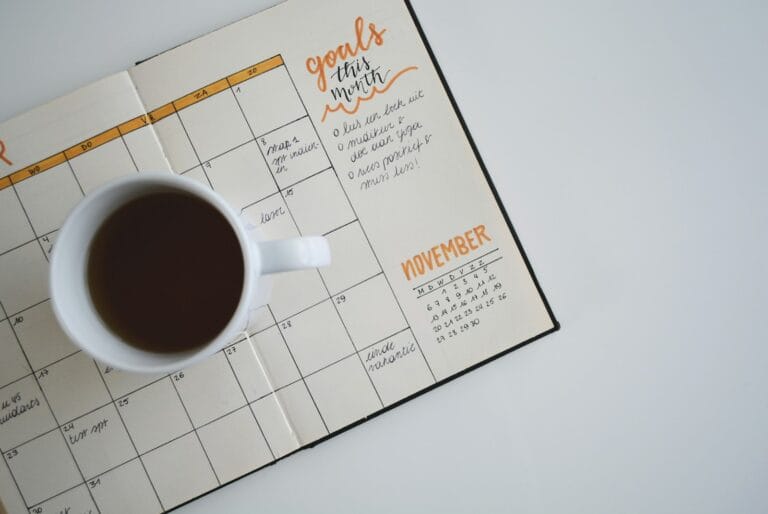 Coffee mug on an open monthly planner, a reminder to plan your timing when you refinance from HSBC