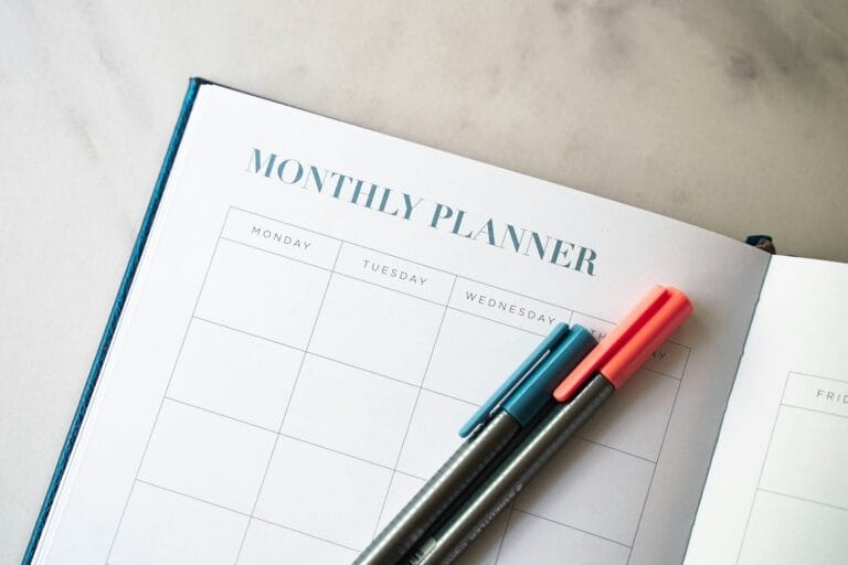 Open planner with two pens, for mapping out the steps to buying a home before deciding when to see a mortgage broker
