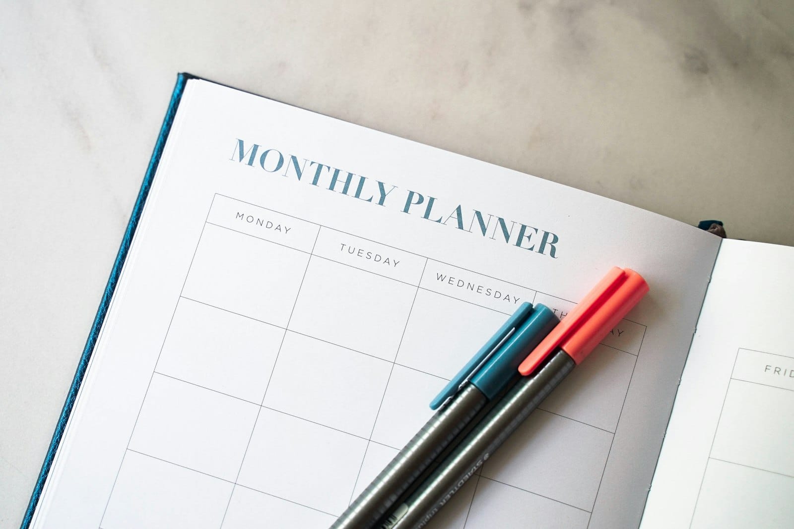 Open planner with two pens, for mapping out the steps to buying a home before deciding when to see a mortgage broker